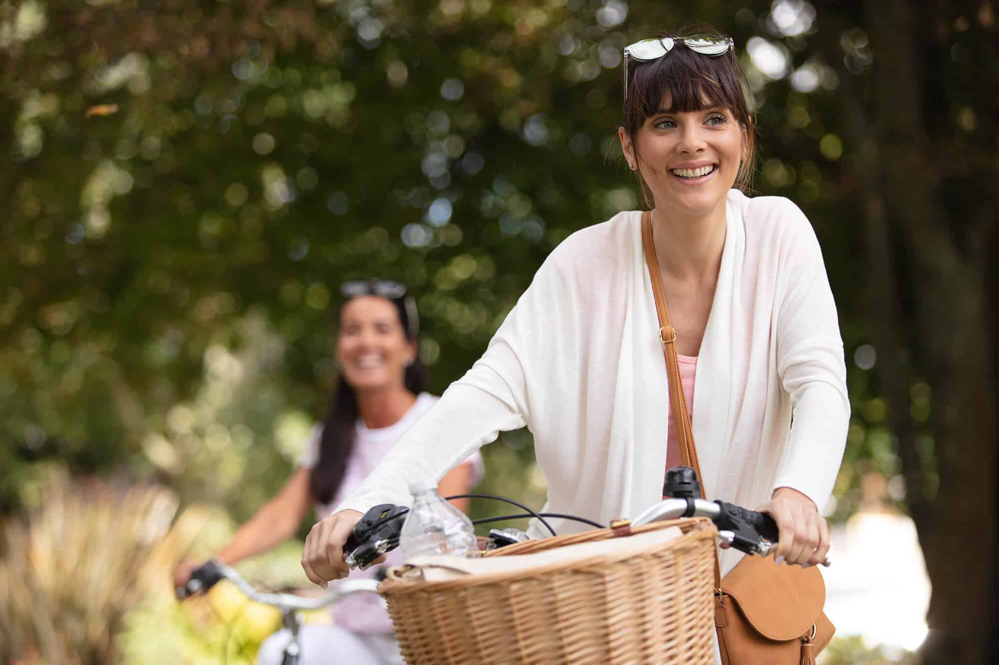 Person riding a bike with a basket on the handle bars depicting the vibrant lifestyle at Flora apartments in summerville sc - AdobeStock 461030147
